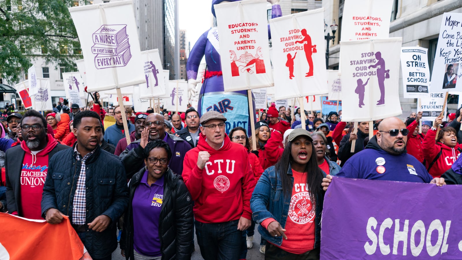 Chicago Teachers Union President Jesse Sharkey (center-left) and Vice President Stacy Davis Gates (center-right) march in downtown Chicago during the union's 11-day strike last fall.
