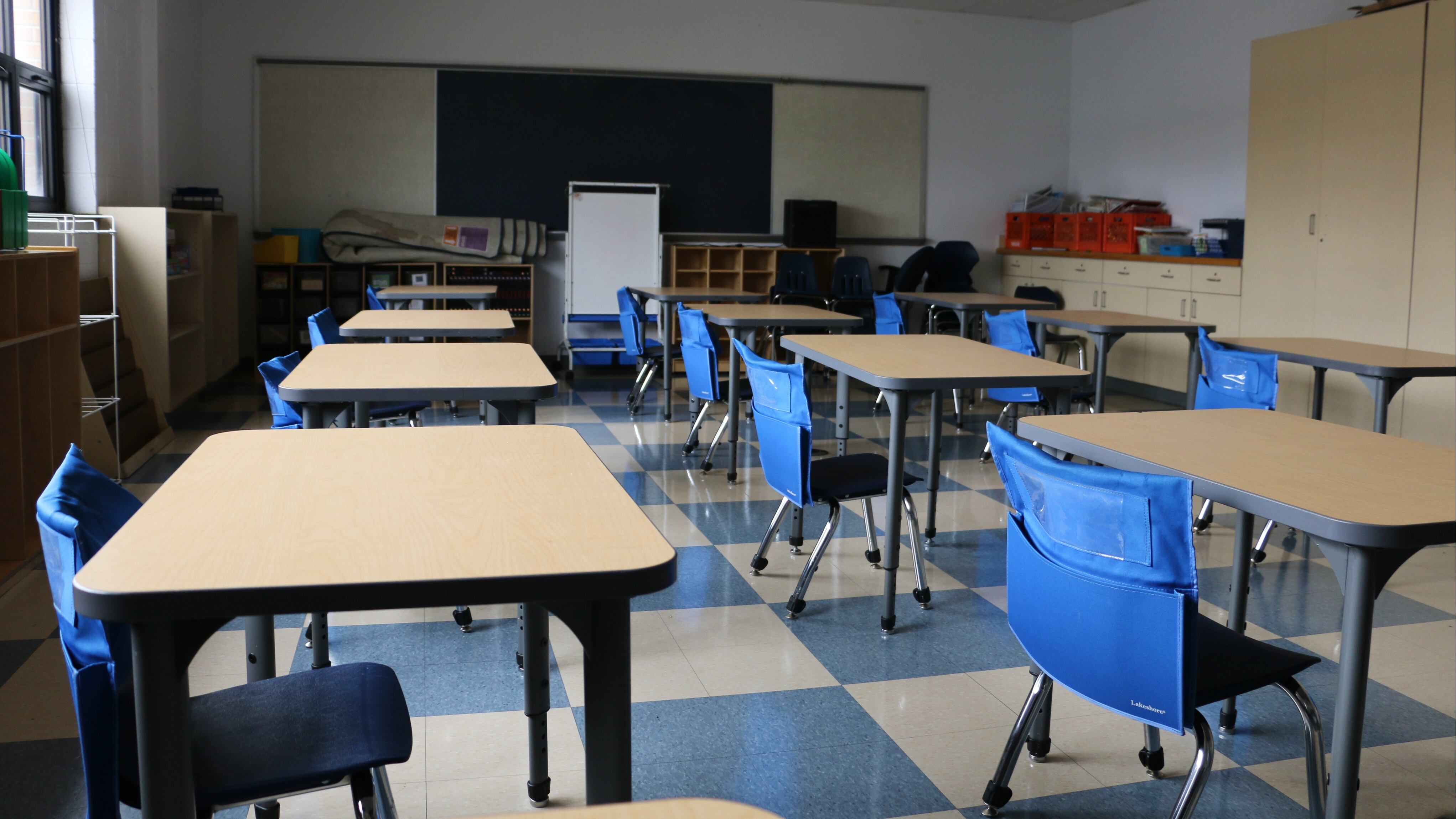 A classroom with blue chairs sits empty.