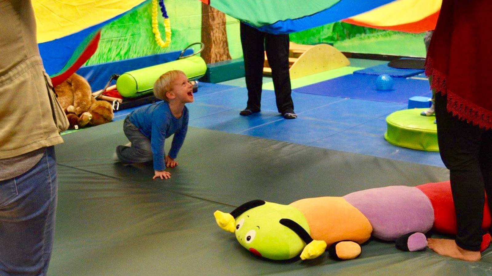 A child plays under a colorful parachute at the SUNY Cortland Sensory Integration/Motor Sensory (SIMS) Movement Exploration Center, where undergraduates training to become physical education teachers have the opportunity to work one-on-one with children of all abilities.