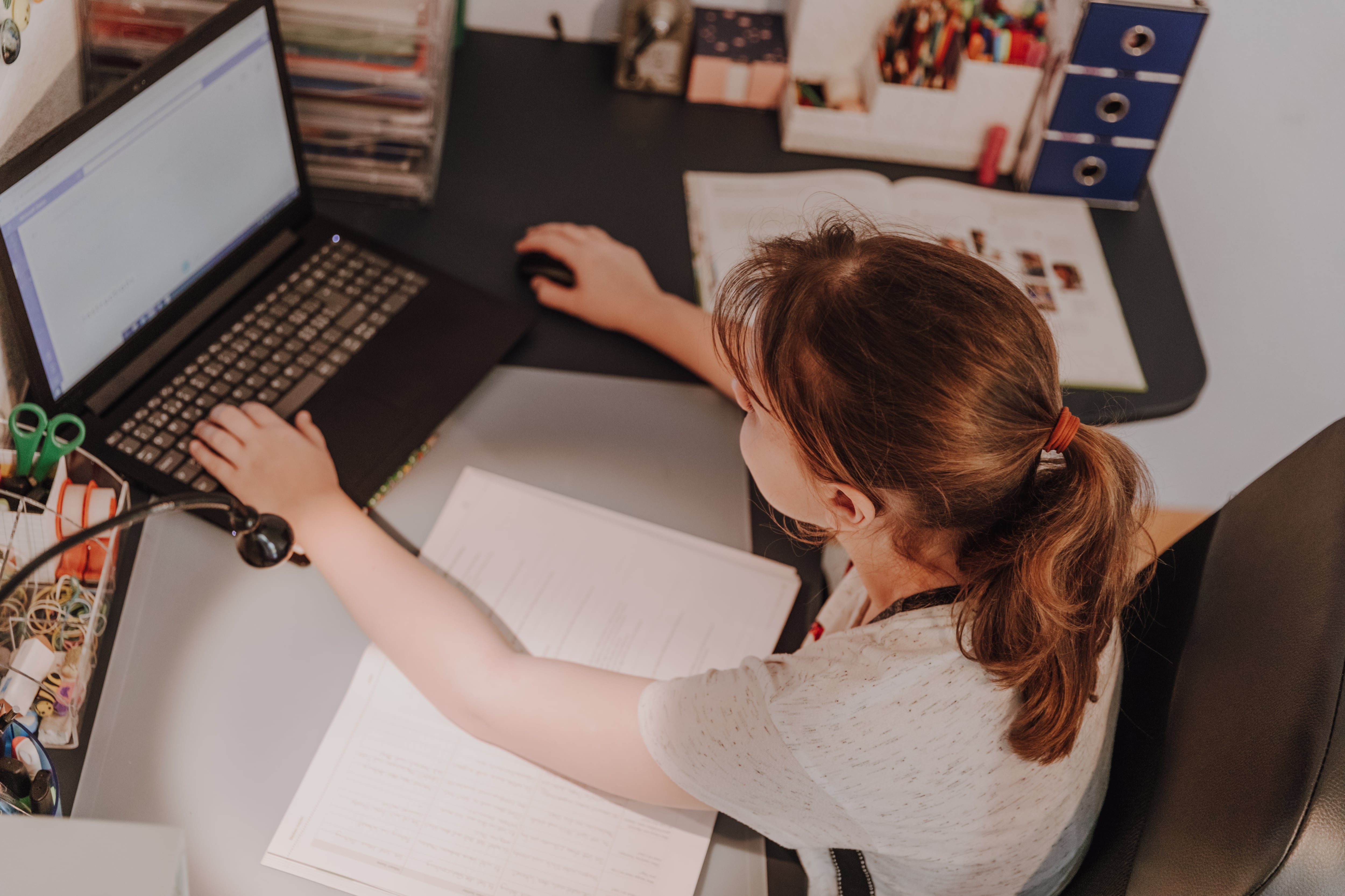 girl in short sleeved shirt works on a computer