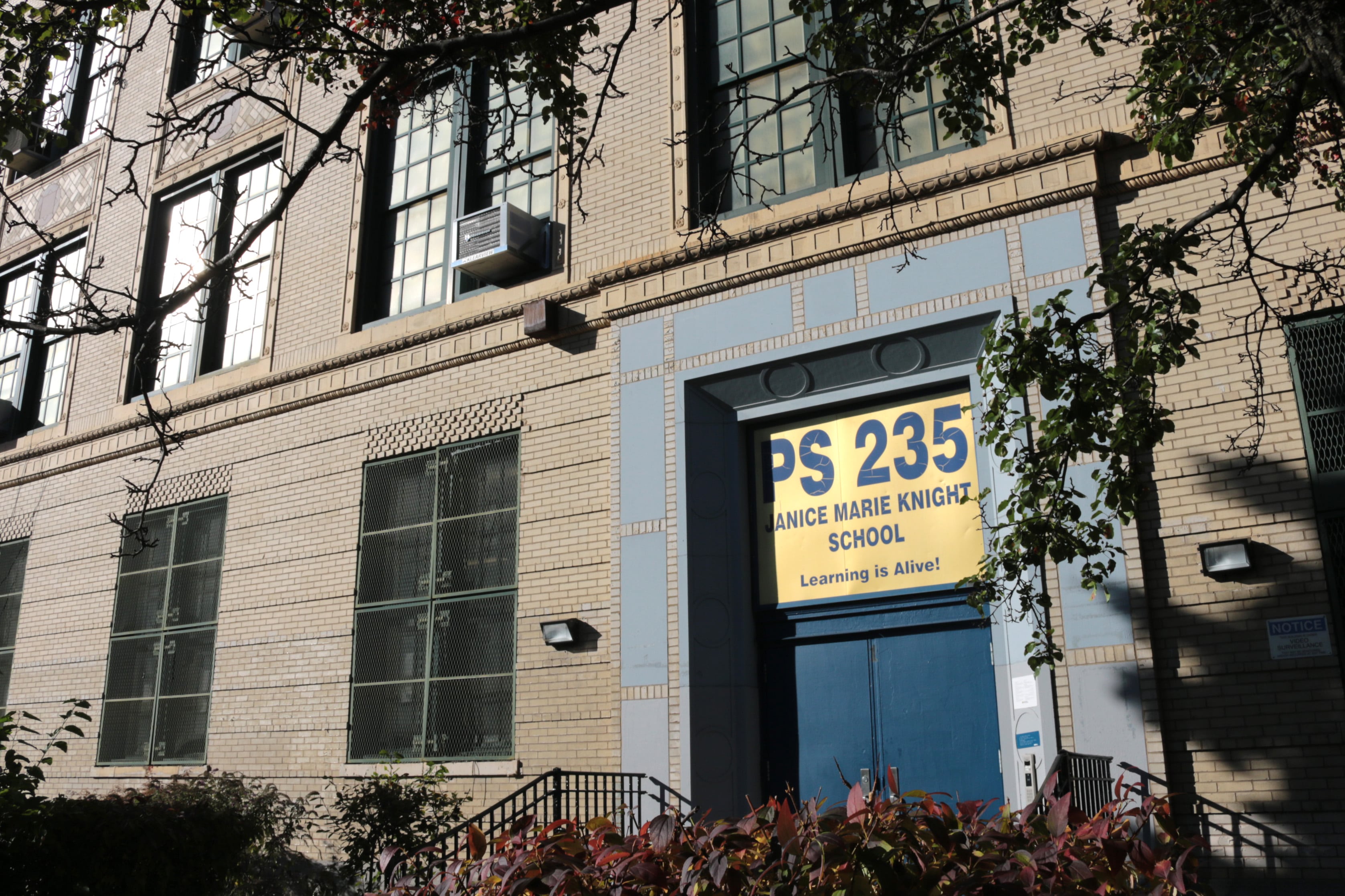 A school sign above the door of a building.