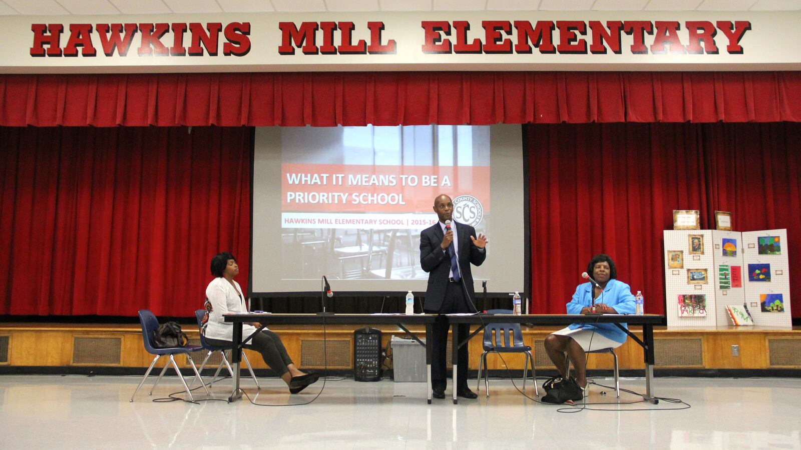 Superintendent Dorsey Hopson, flanked by school board members Stephanie Love and Teresa Jones, speaks at a priority school community meeting in Memphis.