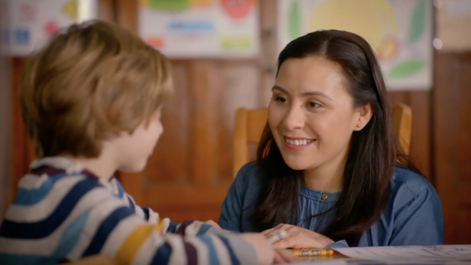 In a new ad released by The United Federation of Teachers, a teacher crouches at a student's desk and smiles.