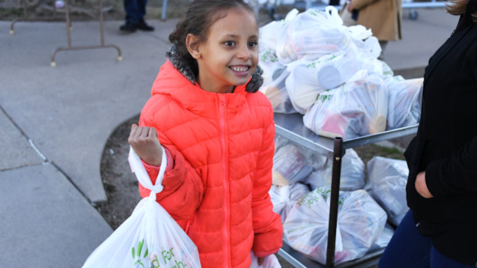 Da’vida Jones, 7, picks up a free meal and some extra food given out at Cowell Elementary on March 16, 2020 in Denver, Colorado.