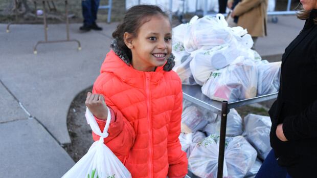 Da’vida Jones, 7, picks up a free meal and some extra food given out at Cowell Elementary on March 16, 2020 in Denver, Colorado.
