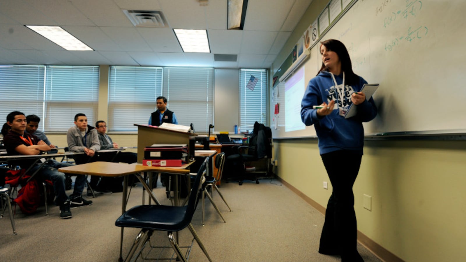 Hinkley High School student Catherine Gibson turns toward her college algebra class to explain a problem she works on the board in 2013 at Hinkley High School in Aurora, Colo. (Photo by Jamie Cotten, Special to The Denver Post)