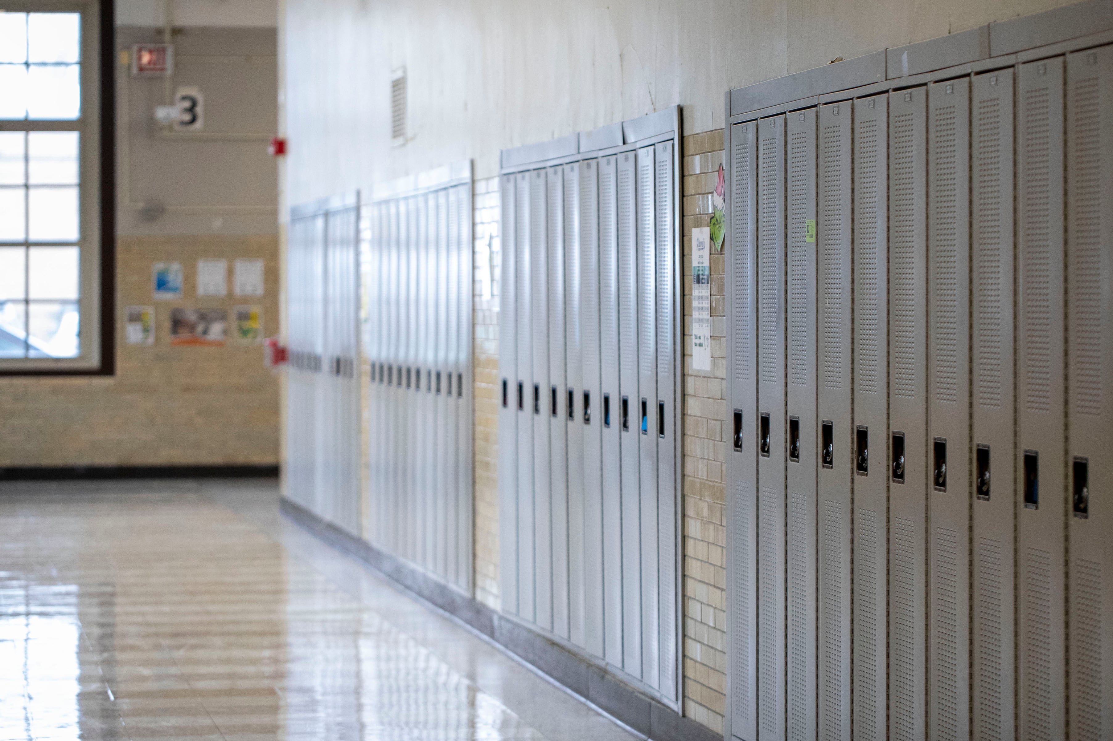 A photograph of a high school hallway showing a row of lockers.