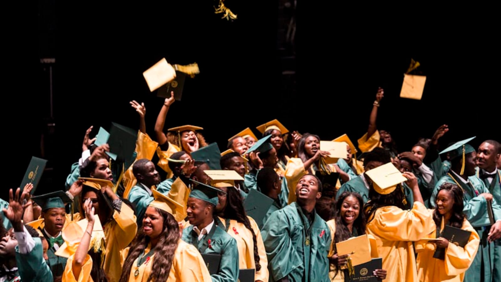 Booker T. Washington High School seniors toss their graduation caps into the air  at the conclusion of their 2016 graduation ceremony at the Orpheum Theatre.