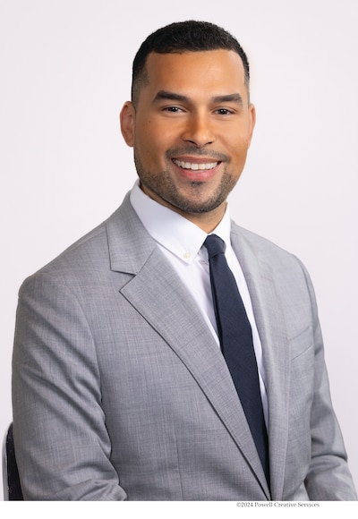 A mug shot of a man with a light gray suit jacket