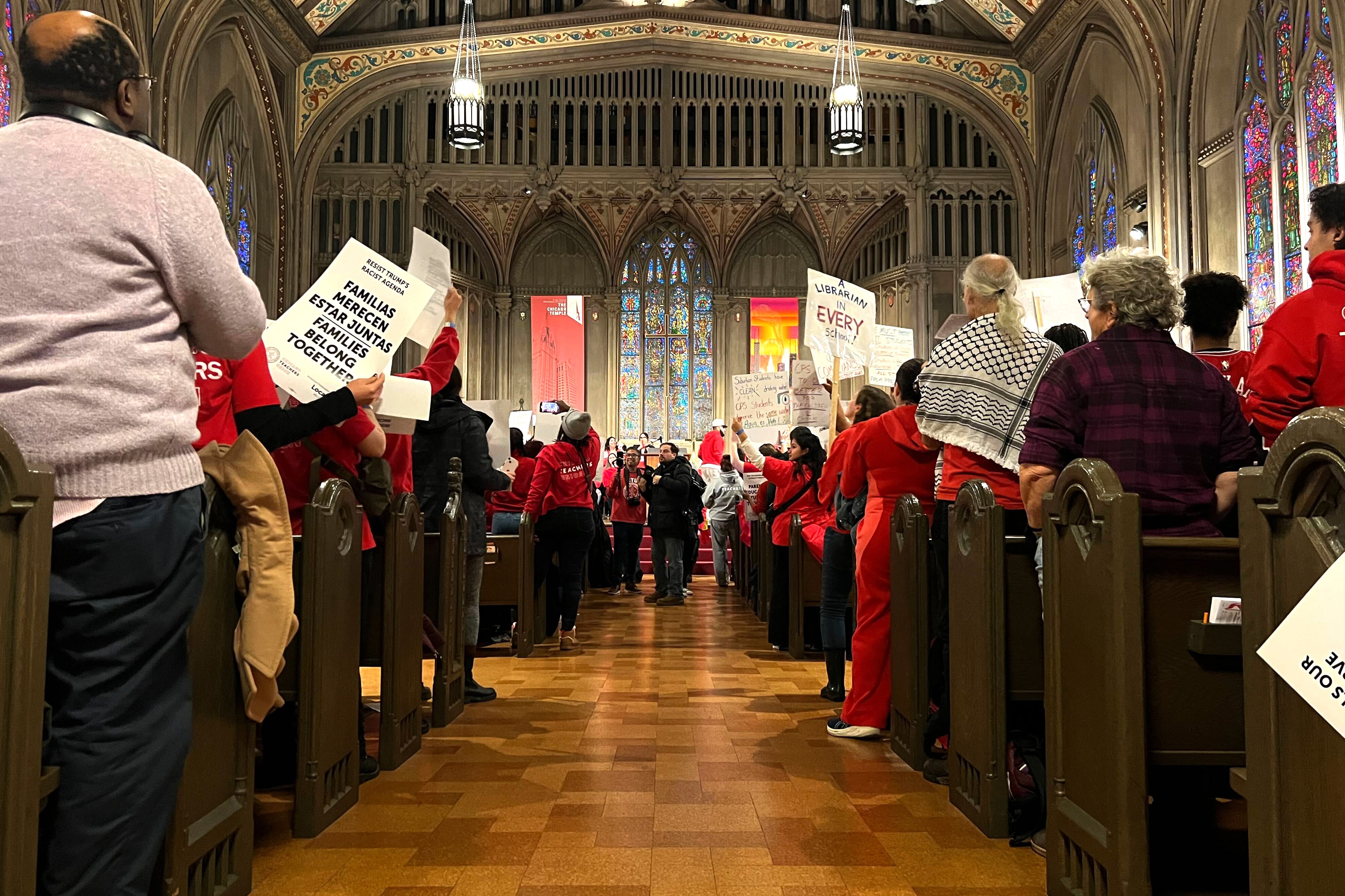 A crowd  stands in a church.