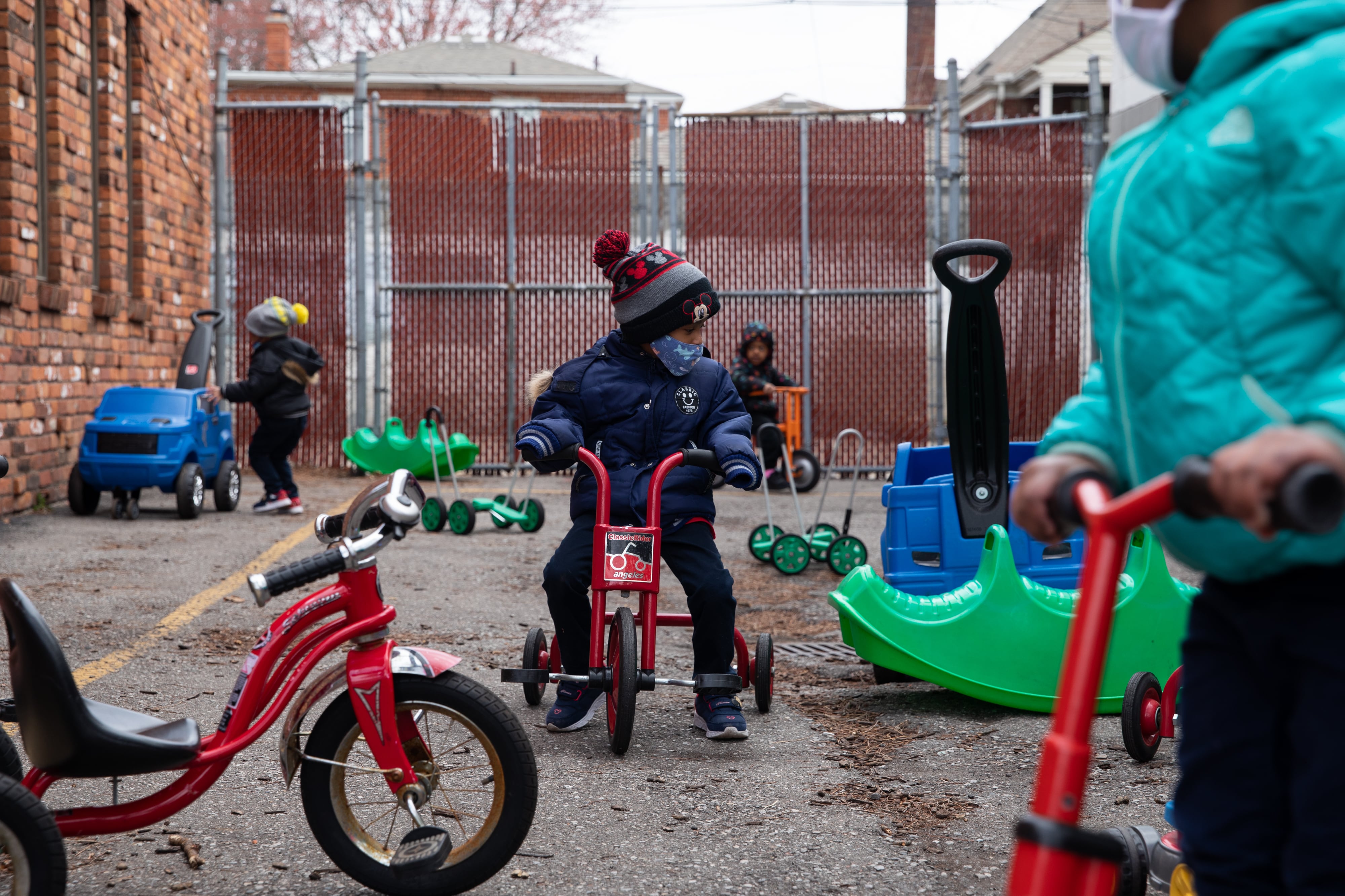 Preschoolers ride around on scooters outside at Little Scholars child care center in Detroit, Michigan, U.S., on Thursday April 1, 2021.