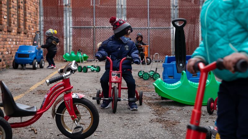 Preschoolers ride around on scooters outside at Little Scholars child care center in Detroit, Michigan, U.S., on Thursday April 1, 2021.