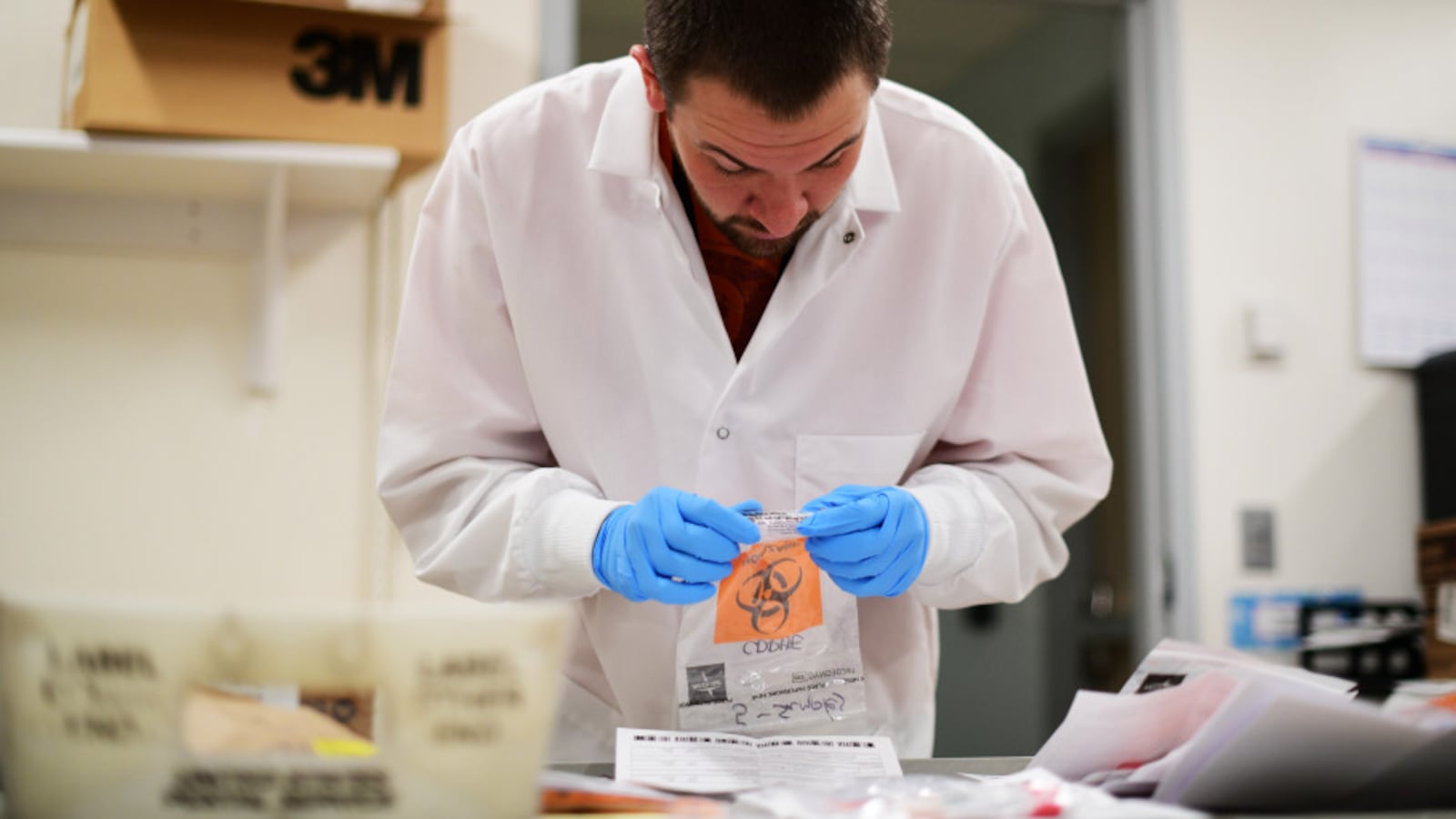 David Storey processes the samples for COVID-19 test at Colorado Department of Public Health and Environment Laboratory Services Division in Denver, Colorado on Saturday. March 14, 2020.