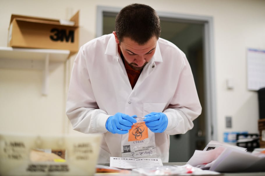 David Storey processes the samples for COVID-19 test at Colorado Department of Public Health and Environment Laboratory Services Division in Denver, Colorado on Saturday. March 14, 2020.