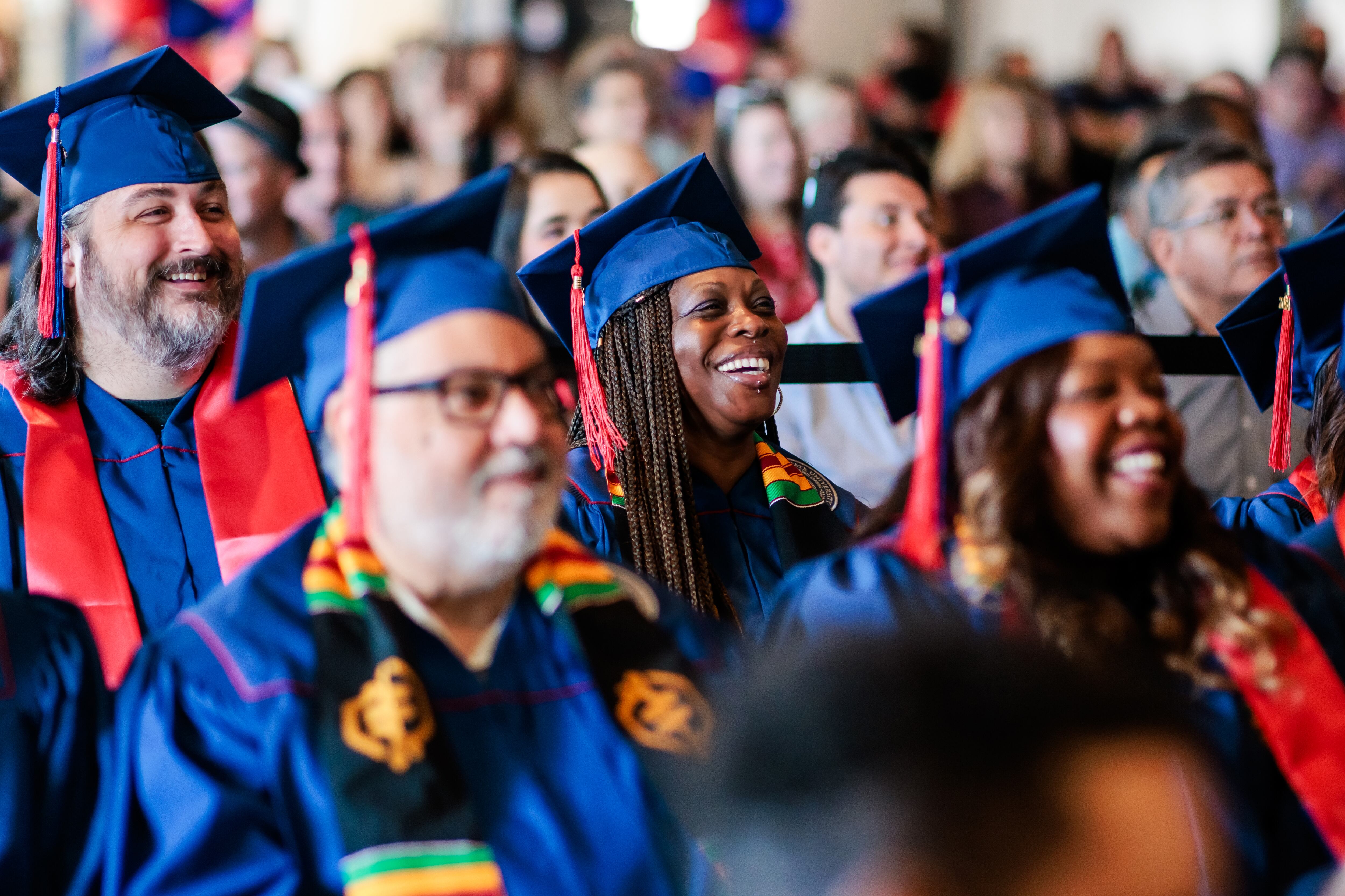People in blue graduation gowns and mortarboards.
