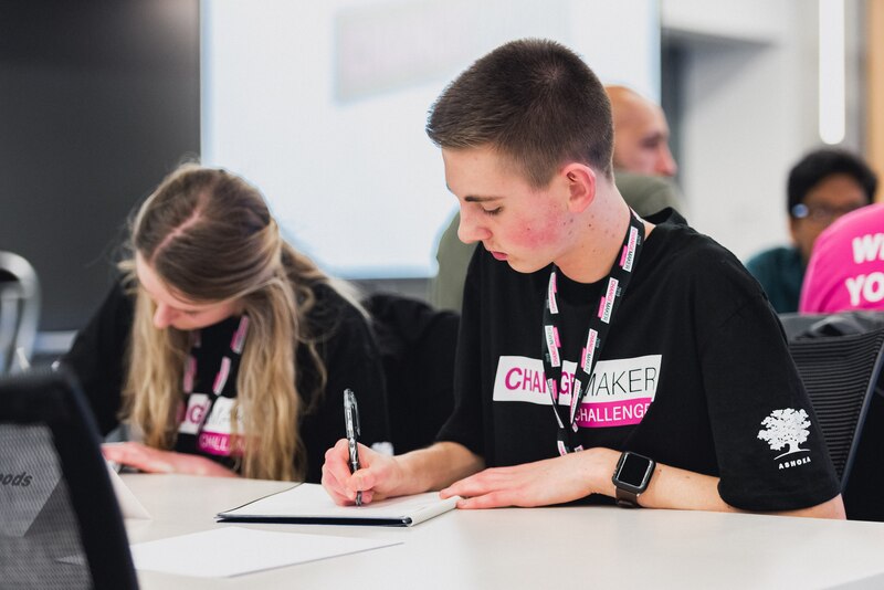 2 students seated at a desk participate in T-Mobile’s Changemaker Challenge