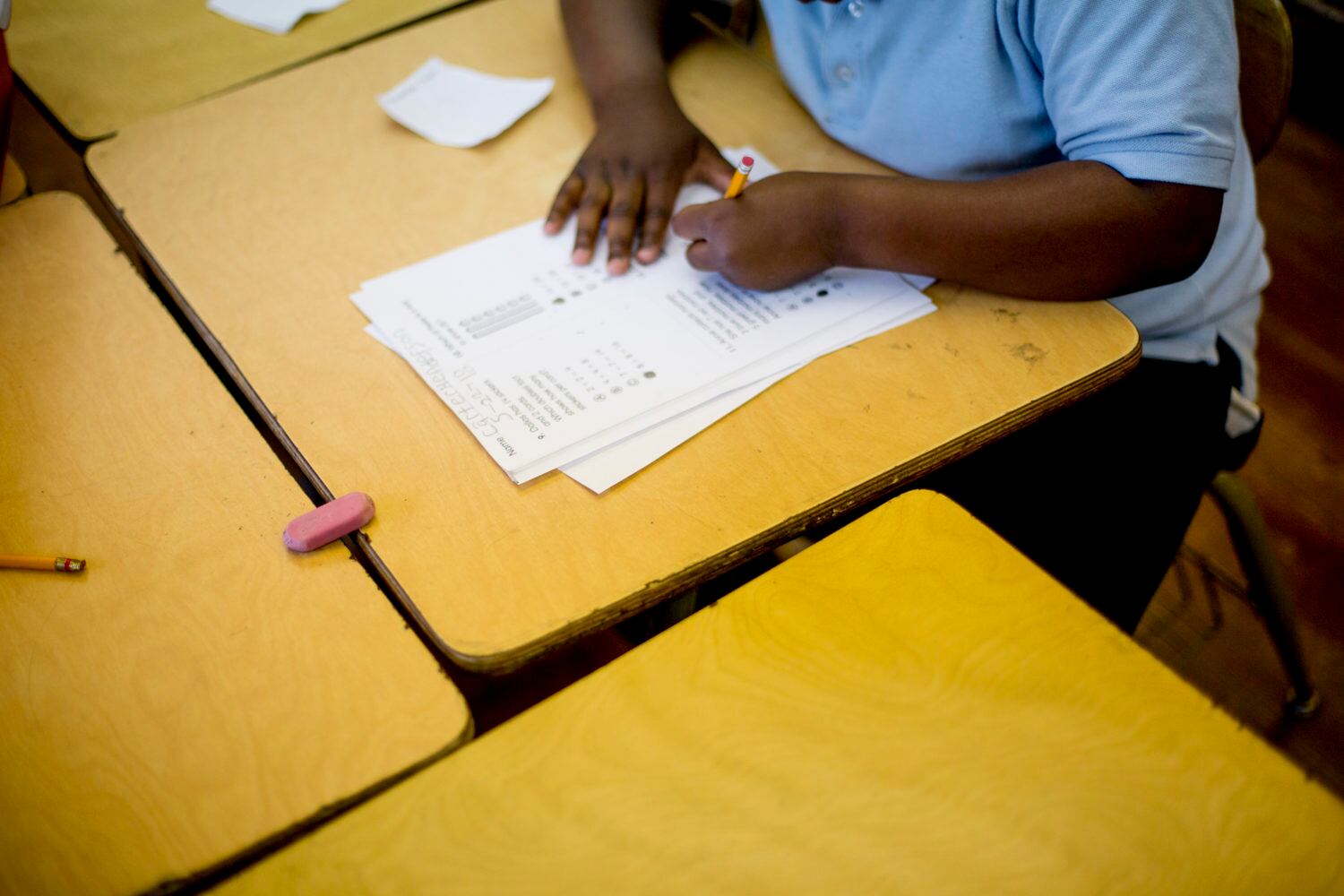 A bird's eye view of a student working on a white sheet of paper.