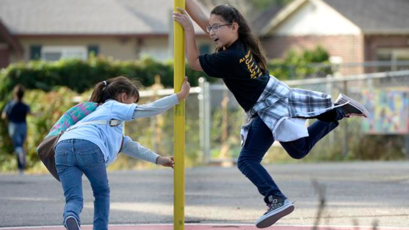 Melisa Piedra-Jara and her sister Jennifer pass time on the Barrett Elementary playground in 2015. Barrett is closing next year and will lose 15 teaching positions.