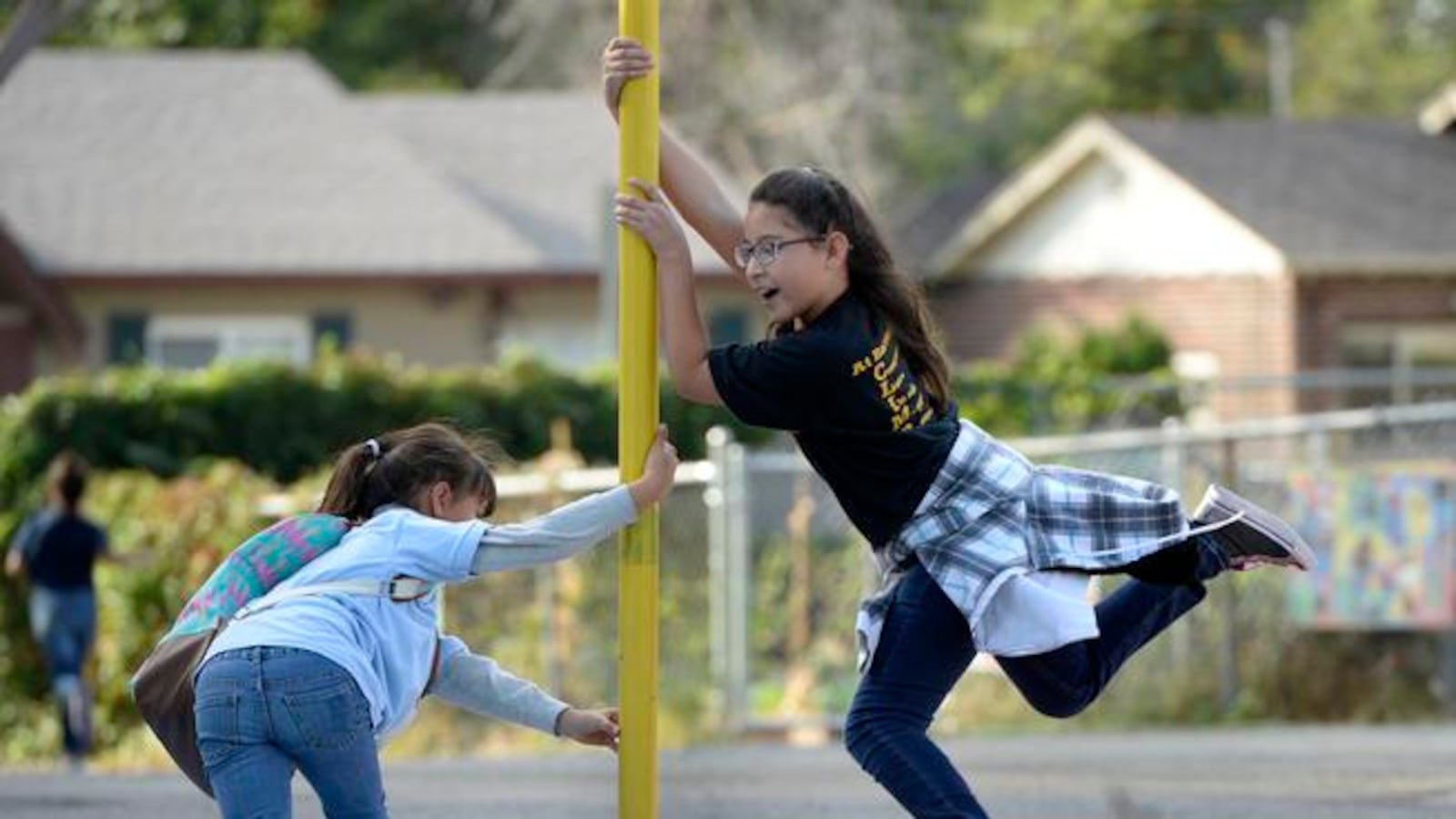 Melisa Piedra-Jara and her sister Jennifer pass time on the Barrett Elementary playground in 2015. Barrett is closing next year and will lose 15 teaching positions.