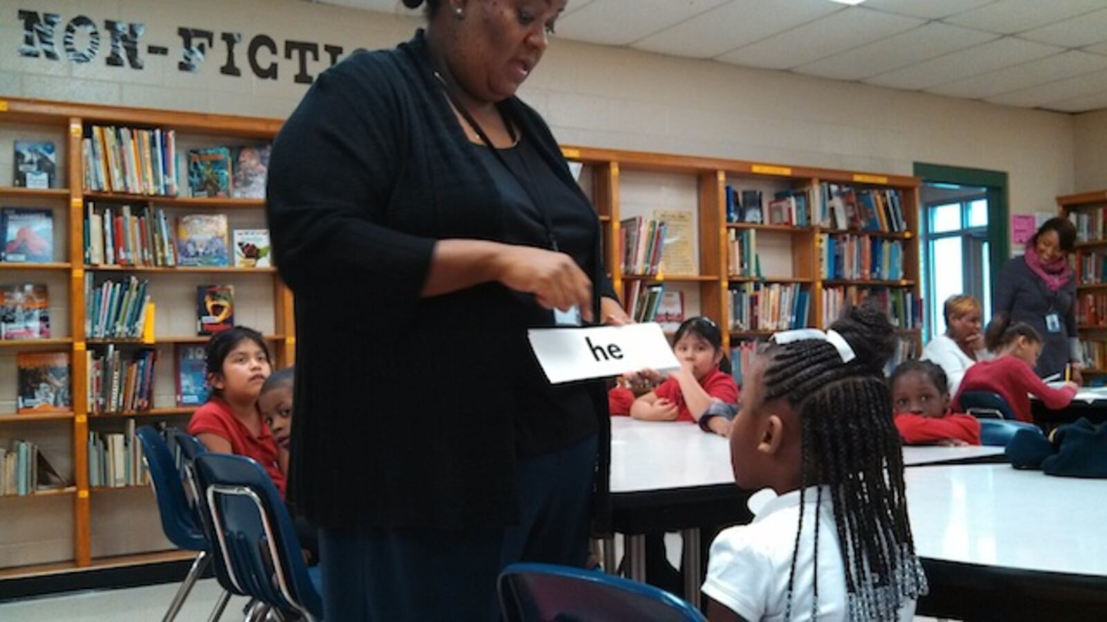 Sharpe Elementary reading interventionist Valencia Ealy works one-on-one with a student on vocabulary words last year in Memphis. Shelby County Schools has started its own program to address lagging literacy scores.
