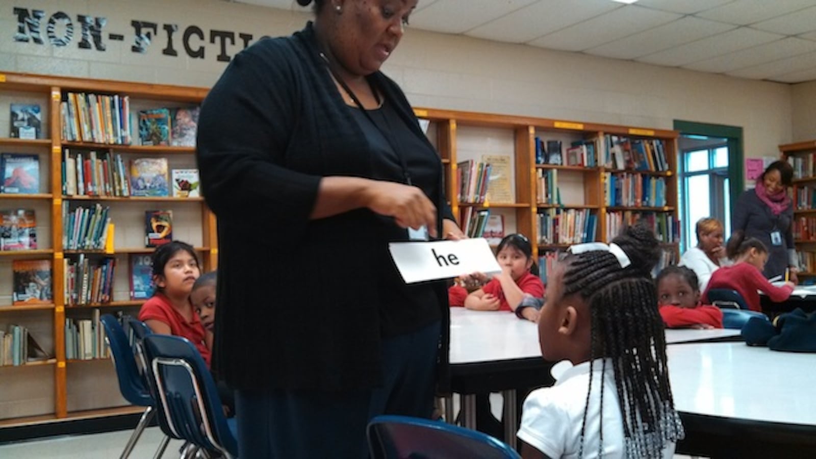 Sharpe Elementary reading interventionist Valencia Ealy works one-on-one with a student on vocabulary words last year in Memphis. Shelby County Schools has started its own program to address lagging literacy scores.