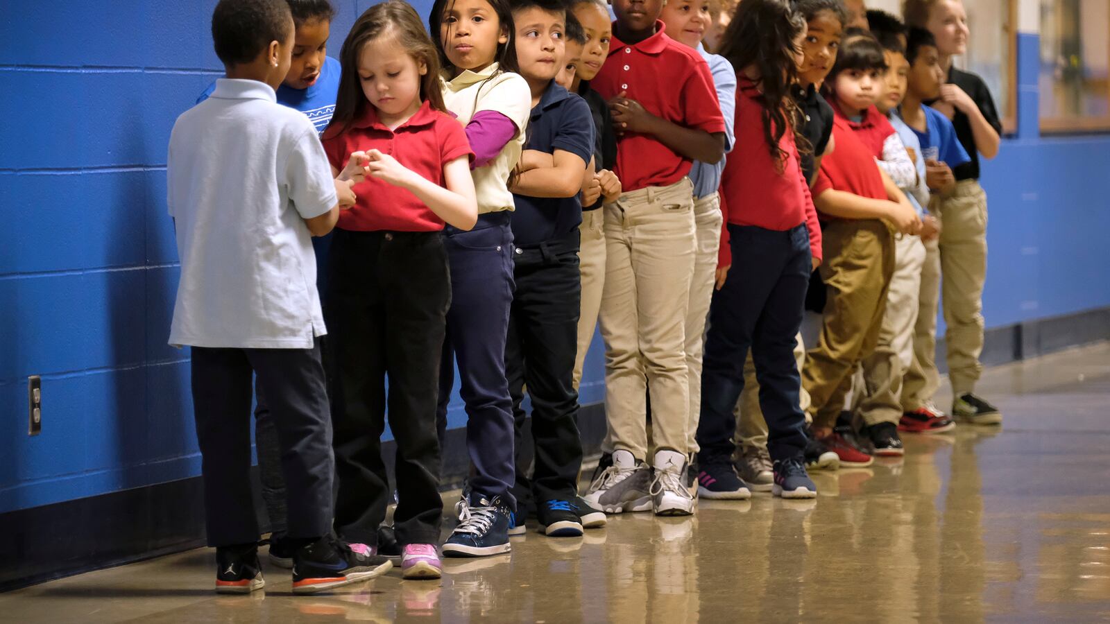 Elementary students in a line in a hallway at Thomas Gregg Neighborhood School, an elementary school in Indianapolis, Indiana. —April, 2019