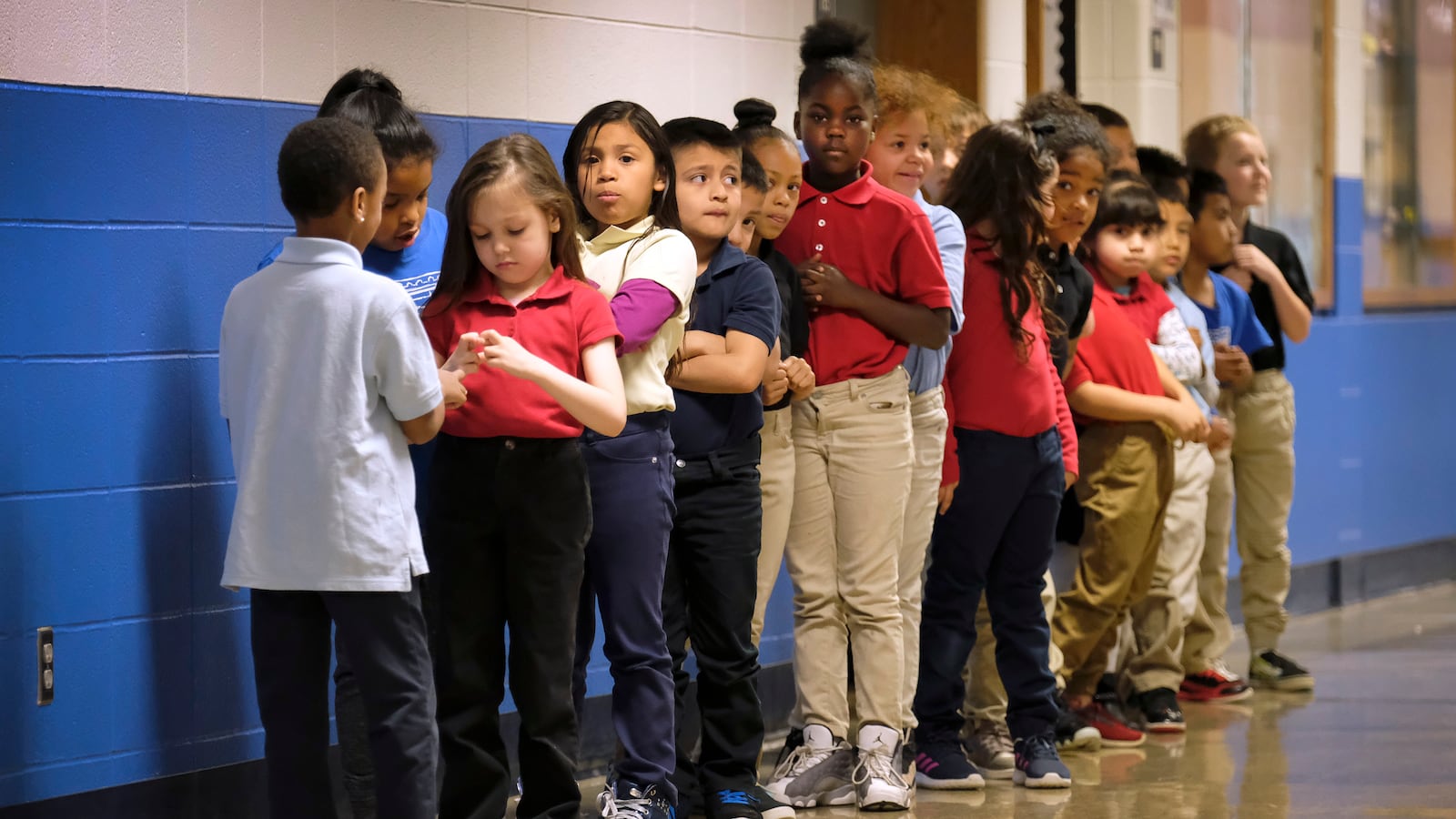 Elementary students in a line in a hallway at Thomas Gregg Neighborhood School, an elementary school in Indianapolis, Indiana. —April, 2019