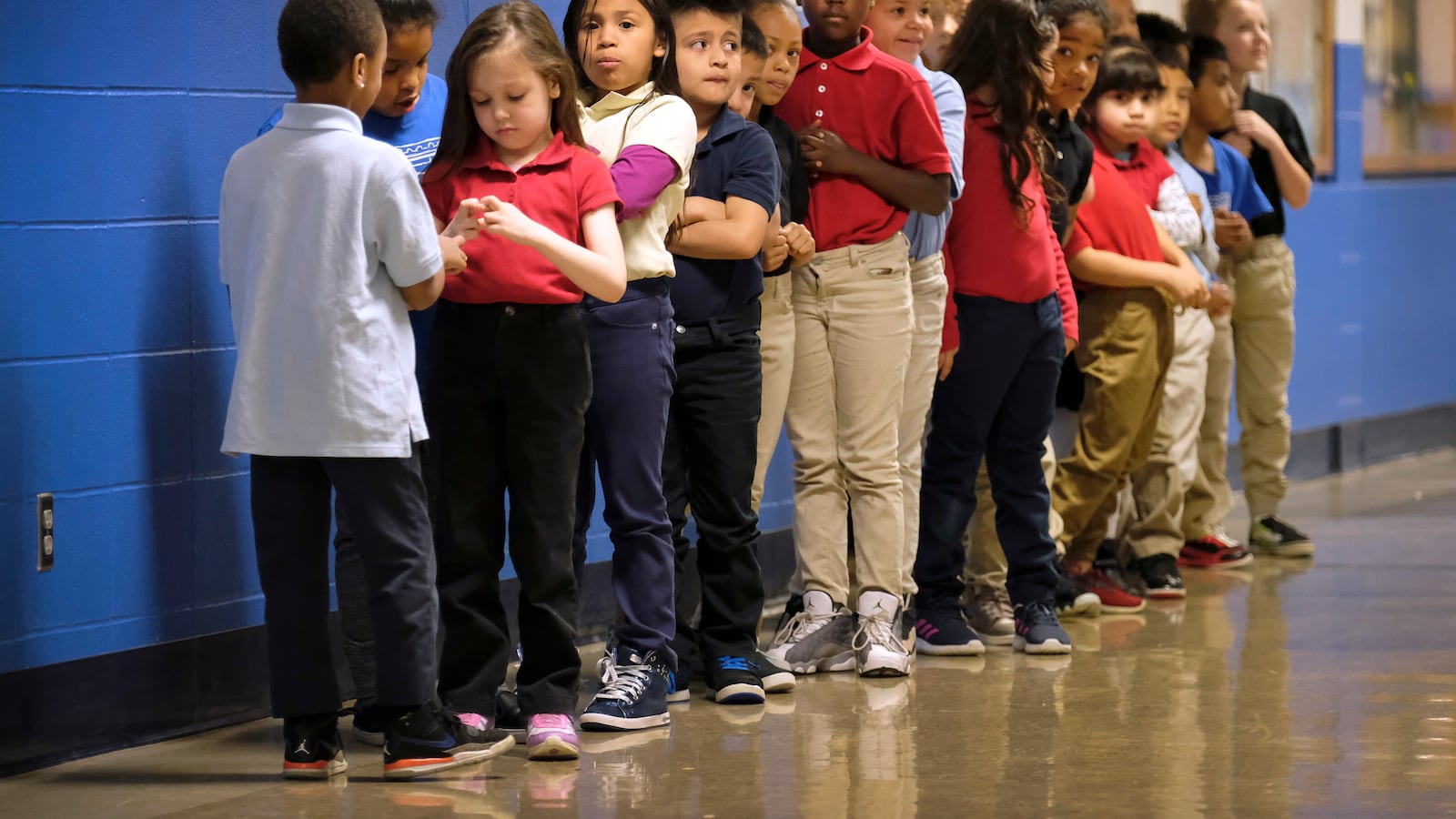 Elementary students in a line in a hallway at Thomas Gregg Neighborhood School, an elementary school in Indianapolis, Indiana. —April, 2019