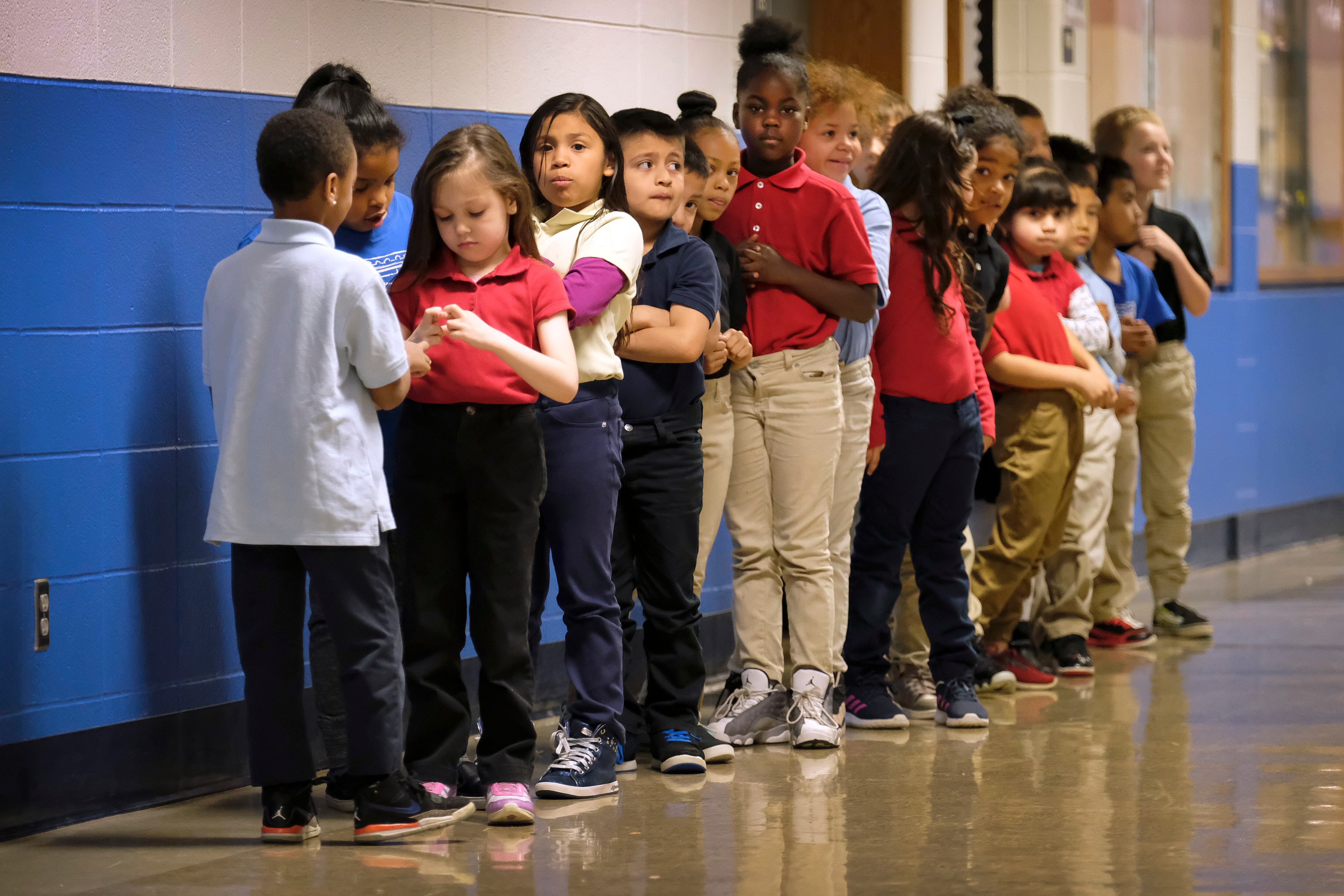 Elementary students in a line in a hallway at Thomas Gregg Neighborhood School, an elementary school in Indianapolis, Indiana. —April, 2019