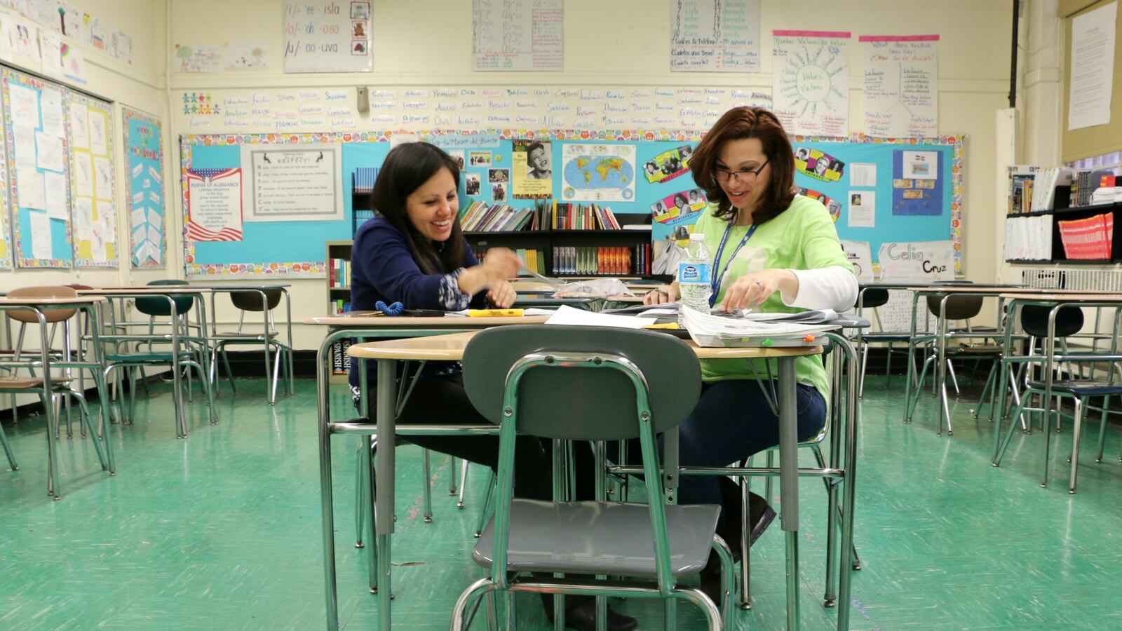 Community school director Fiorella Guevara, left, looks at student writing samples with a bilingual teacher at M.S. 50 in Williamsburg.