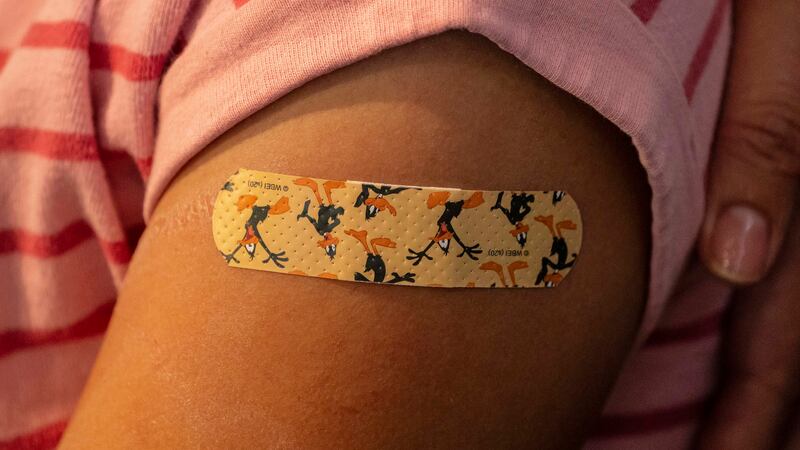 A bandaid adorns a child’s arm. New York City is extending its $100 COVID vaccine incentive program to children who get shots at their school next week.