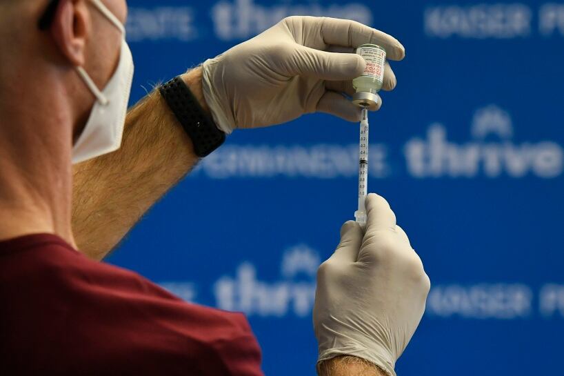 A nurse fills a syringe with COVID-19 vaccine.