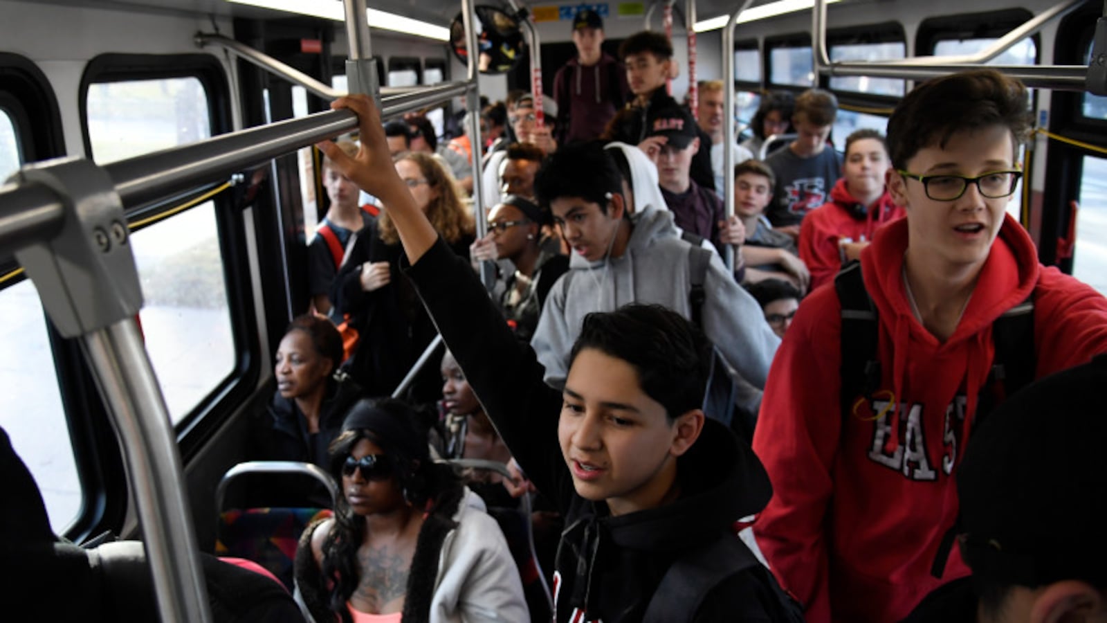 East High School freshman Marcos Chavez, center, hangs onto a handrail on an RTD bus on his way home from school in 2017.