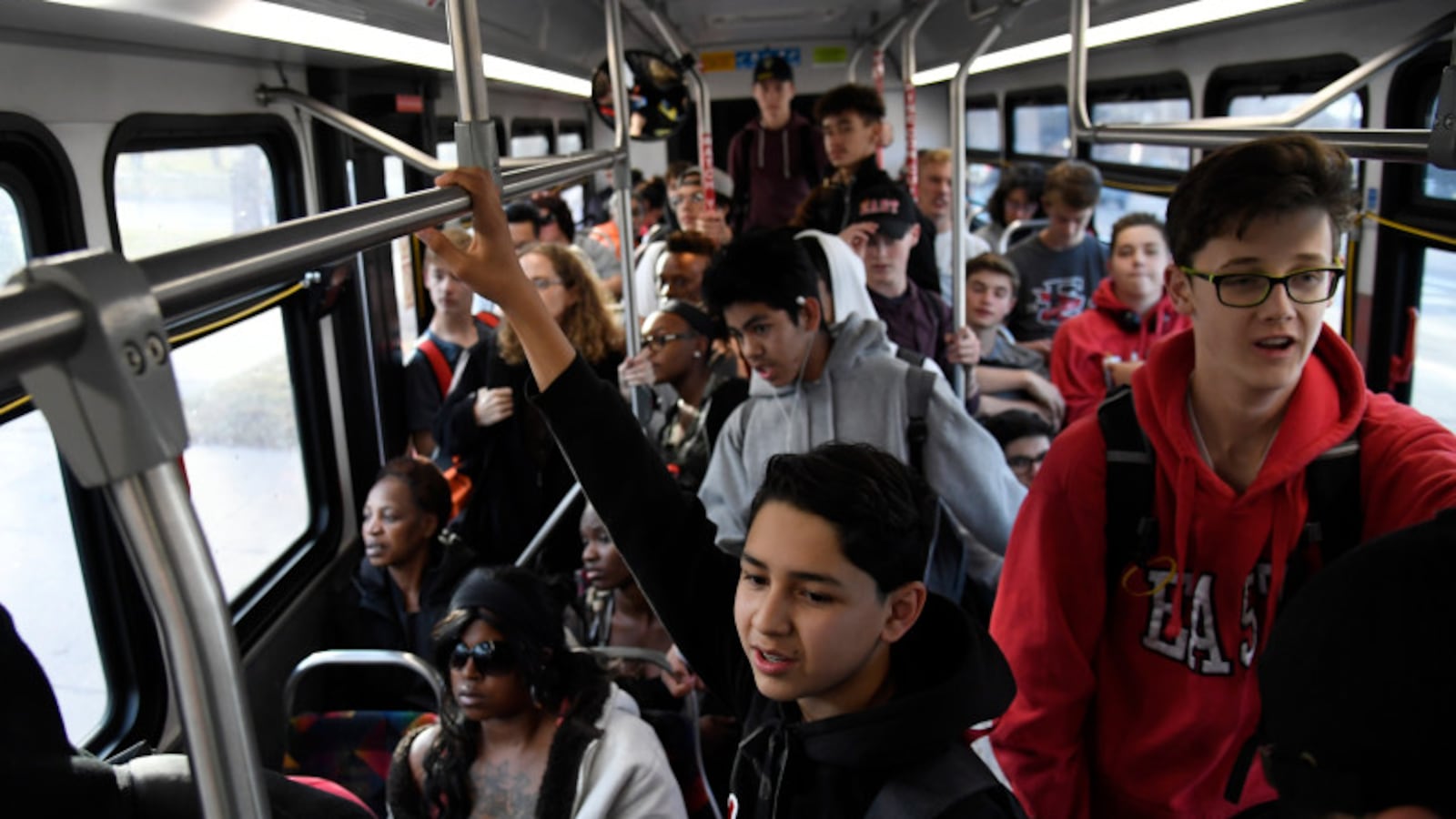 East High School freshman Marcos Chavez, center, hangs onto a handrail on an RTD bus on his way home from school in 2017.