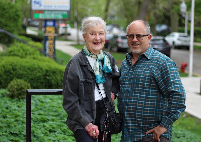 Two adults pose for a portrait outside.