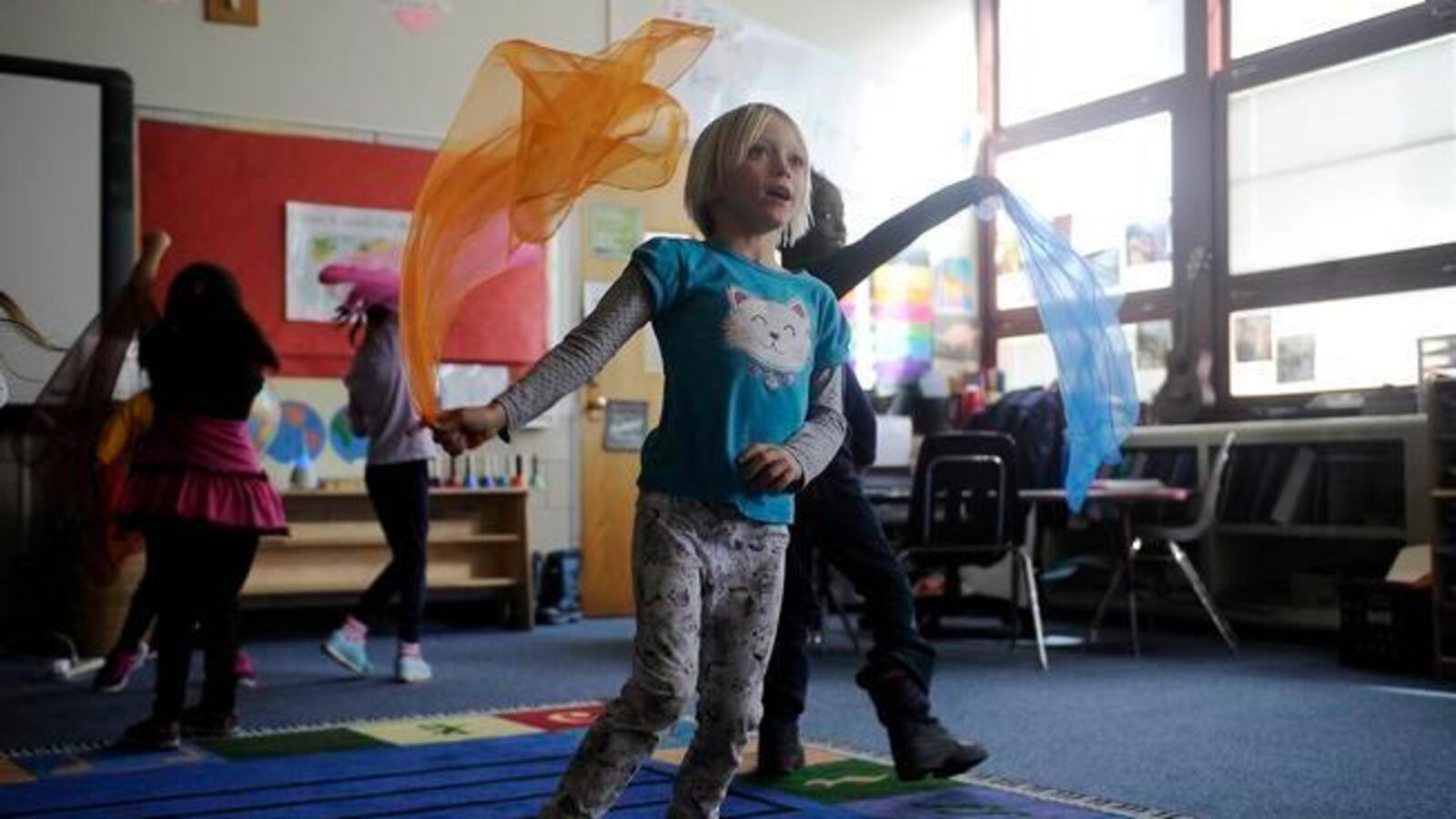 Students dance with brightly colored scarves during a music class at Gilpin Montessori (Denver Post photo).