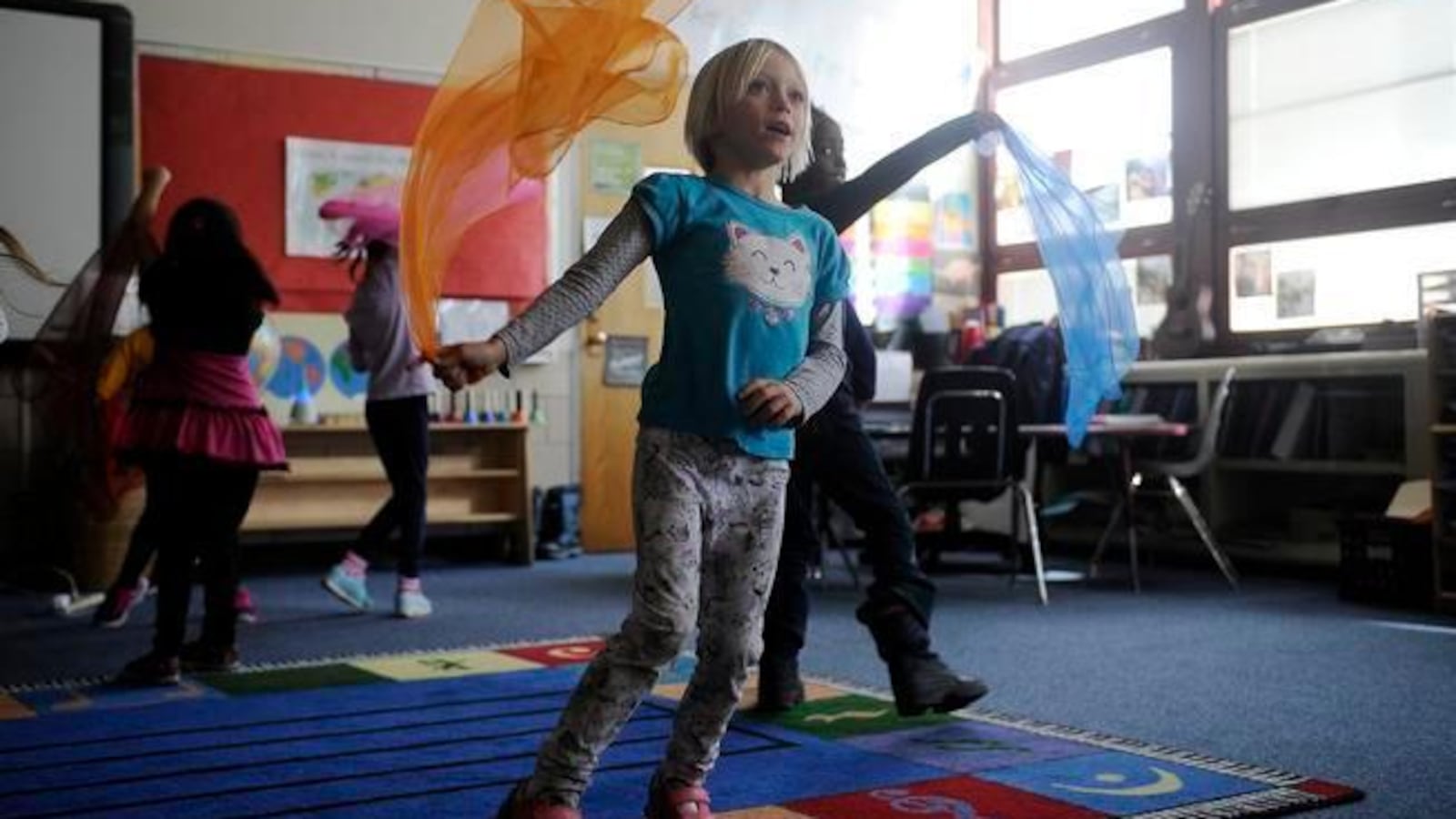 Students dance with brightly colored scarves during a music class at Gilpin Montessori (Denver Post photo).