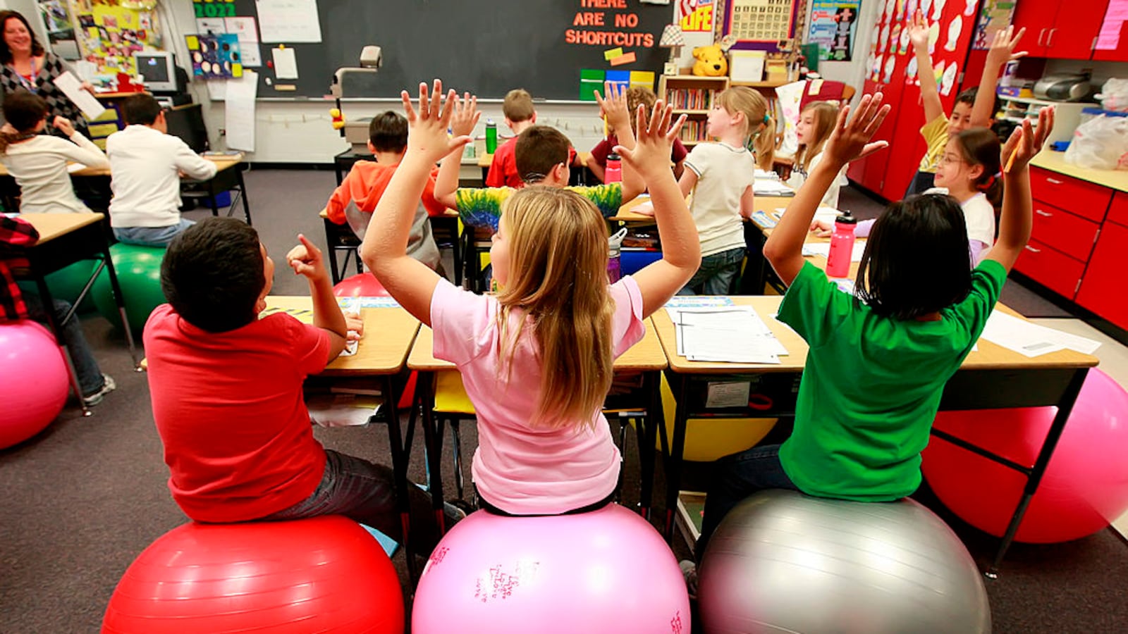 Leela Herena, from right, Emma Miller and Cesar Mendez sit on exercise balls which are used as chairs in a fourth-grade classroom at Creekside Elementary School in Elgin, Illinois, on October 26, 2009.  (Photo by Stacey Wescott/Chicago Tribune/MCT via Getty Images)