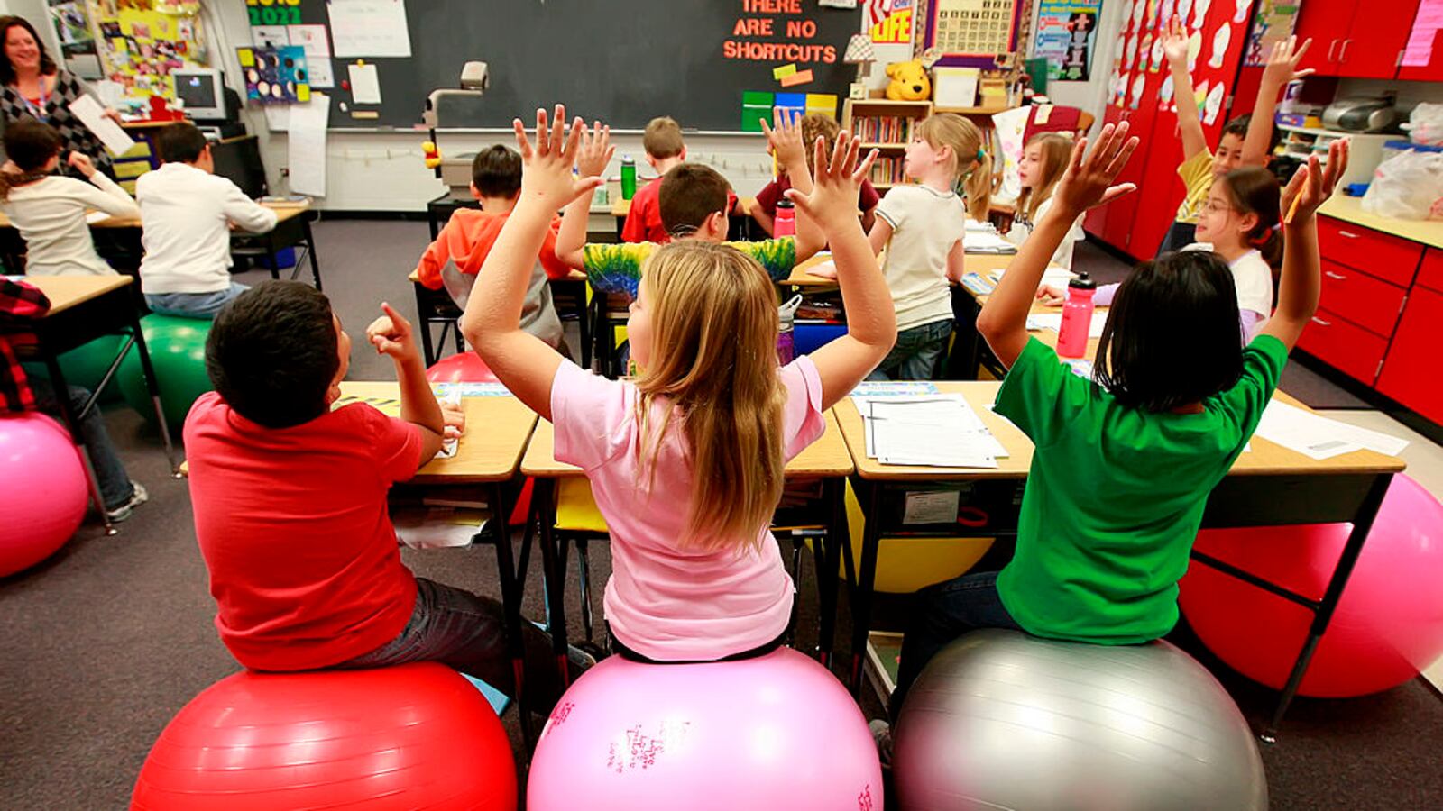 Leela Herena, from right, Emma Miller and Cesar Mendez sit on exercise balls which are used as chairs in a fourth-grade classroom at Creekside Elementary School in Elgin, Illinois, on October 26, 2009.  (Photo by Stacey Wescott/Chicago Tribune/MCT via Getty Images)