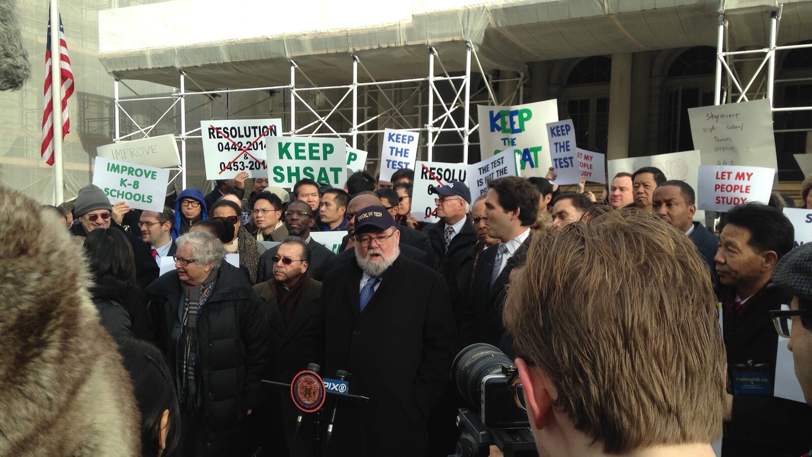 Coalition of Specialized High School Alumni Organizations President Larry Cary rallies a crowd of alumni and parents of specialized high school students outside City Hall.