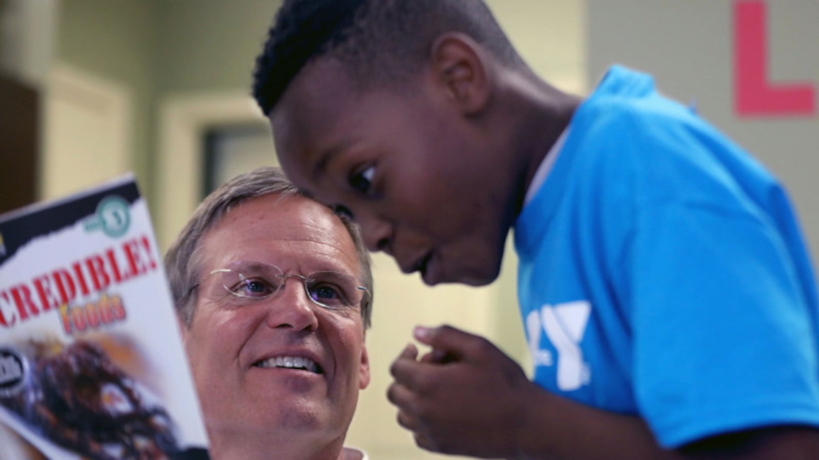 Tennessee Gov. Bill Lee reads to a child while visiting an apartment complex in Memphis on Tuesday.