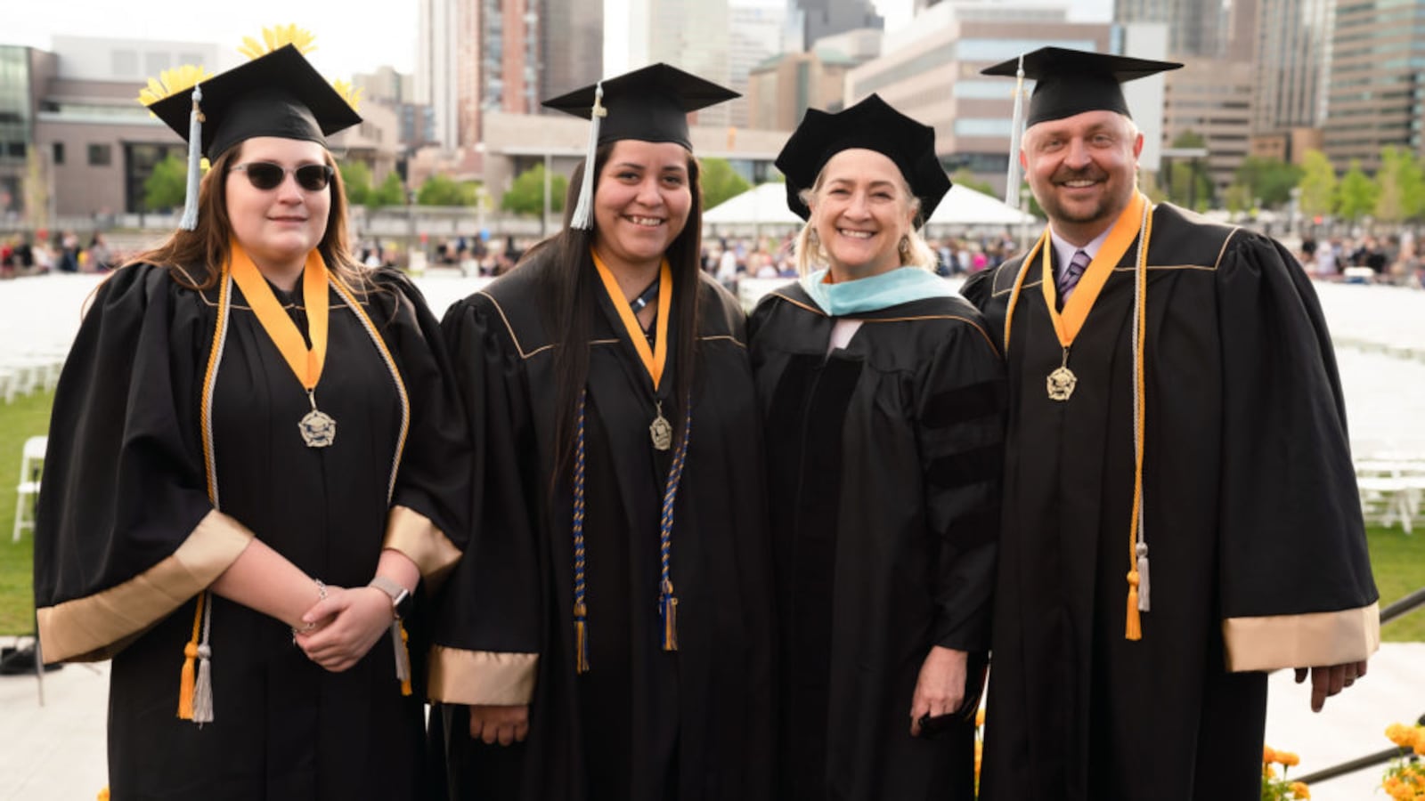 Brooke Waring, left, NaTasha Montoya, and James Osborn are the first graduates of a University of Colorado Denver partnership with Otero Junior College. At commencement, they posed with Associate Dean Barbara Seidl.