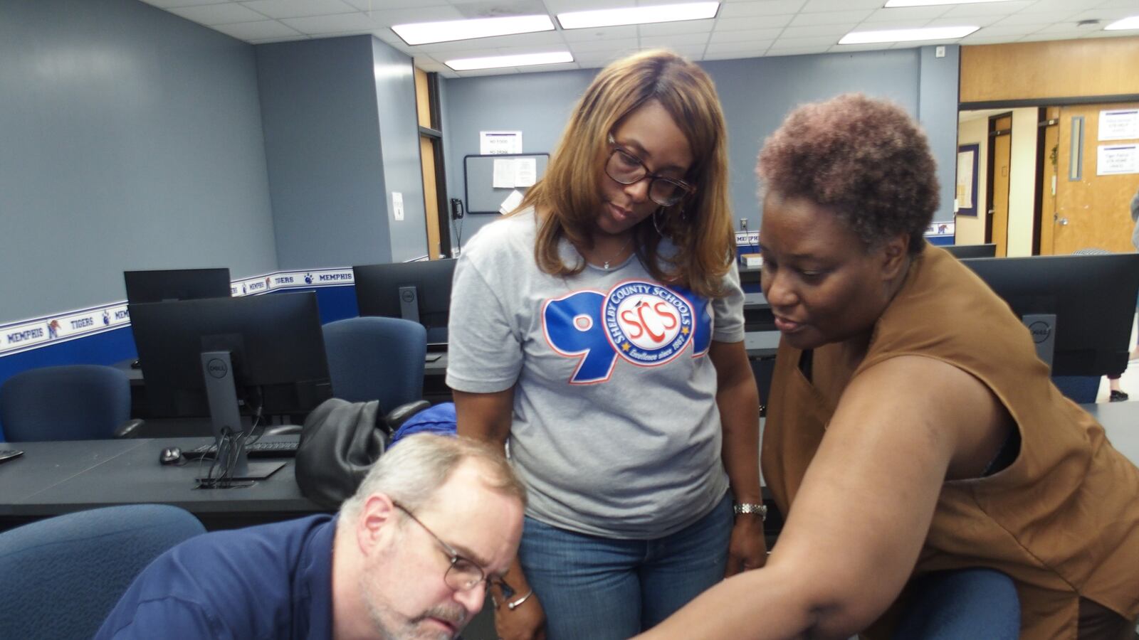 University of Memphis engineering professor Daniel Kohn (left) helps local science teachers Iris Myers (center) and Sonya Boyce program a robot during a robotics teacher training on campus. July 23, 2019.