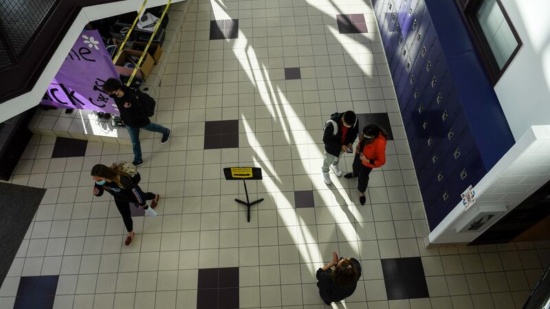 Students walk the halls in small groups between classes during the first day of in-person learning at a high school in Jefferson County, Colorado.