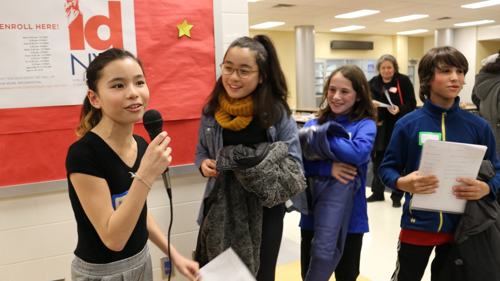 Matilda and Eliza Seki, left, and their friends Noa and Benji Weiss, right, collected signatures at a district 15 meeting to discuss middle school integration efforts.