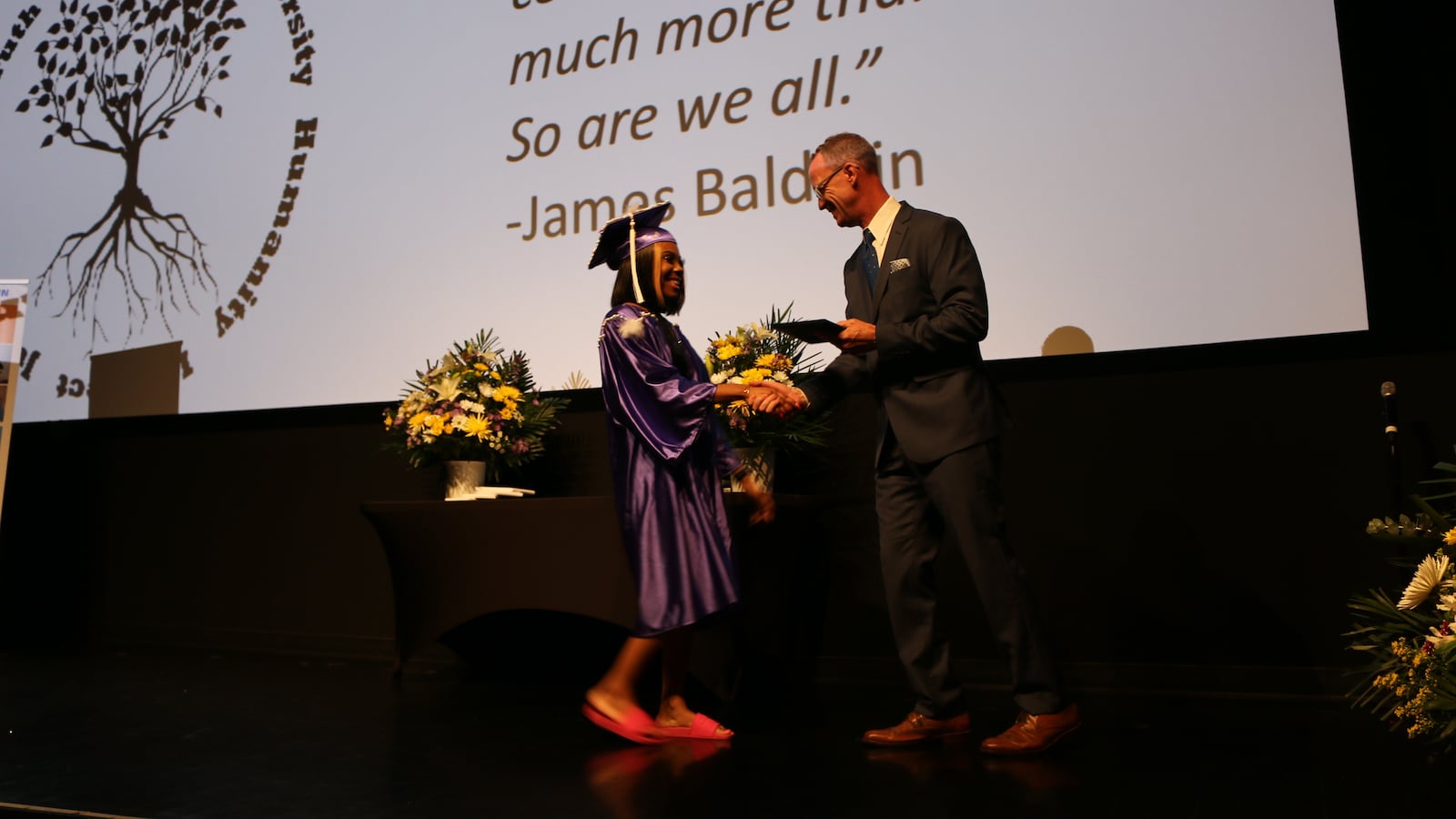A student receives her diploma from Principal Brady Smith during the James Baldwin School's graduation in June 2019.