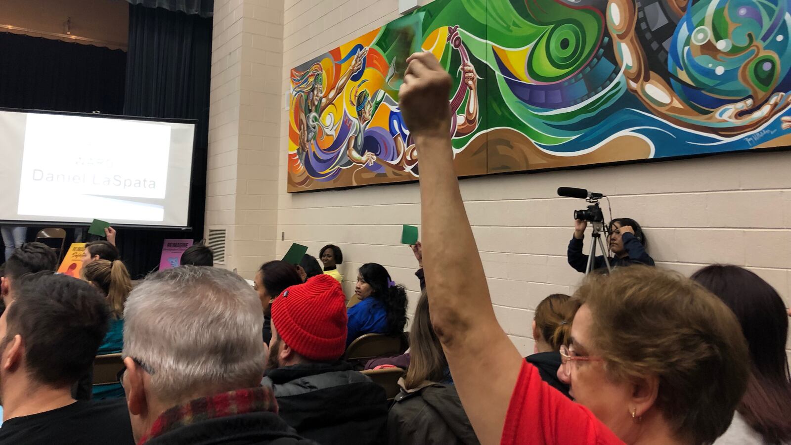 An audience member holds up a green sign showing support at a forum for Northwest side aldermanic candidates. The forum was sponsored by the Logan Square Neighborhood Association.