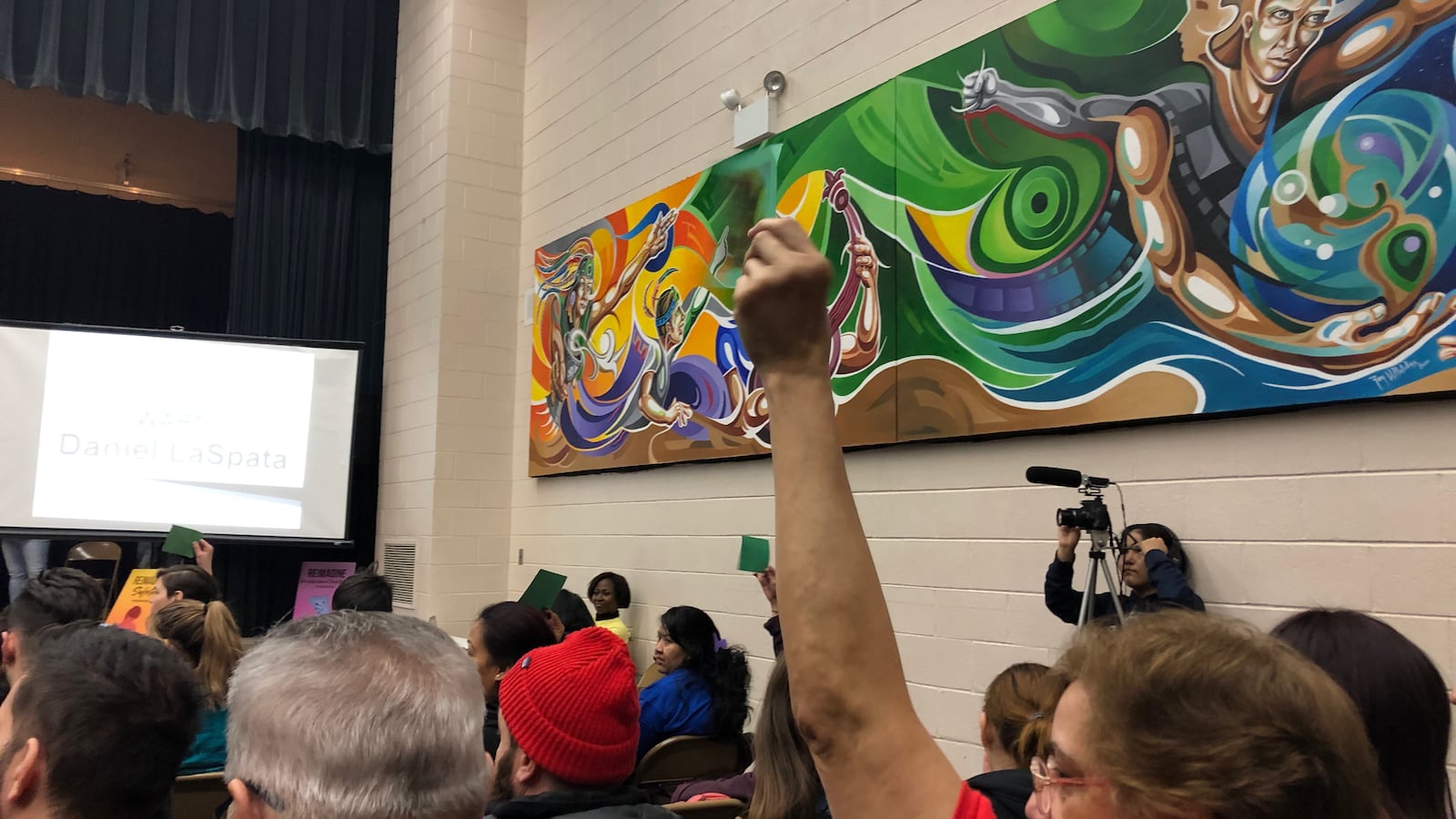 An audience member holds up a green sign showing support at a forum for Northwest side aldermanic candidates. The forum was sponsored by the Logan Square Neighborhood Association.