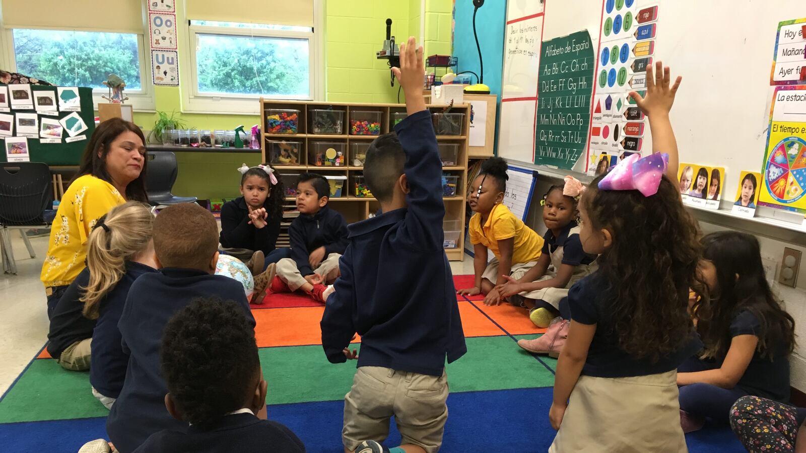 Pre-K students raise their hands during morning circle time at a new bilingual prekindergarten class at Global Preparatory Academy in Indianapolis.