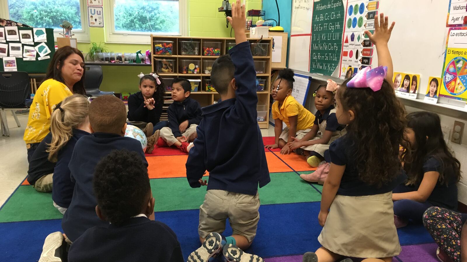 Pre-K students raise their hands during morning circle time at a new bilingual prekindergarten class at Global Preparatory Academy in Indianapolis.